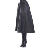 Black leather skirt worn by a person on a white background